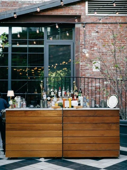 A wood-paneled outdoor bar set up for an event