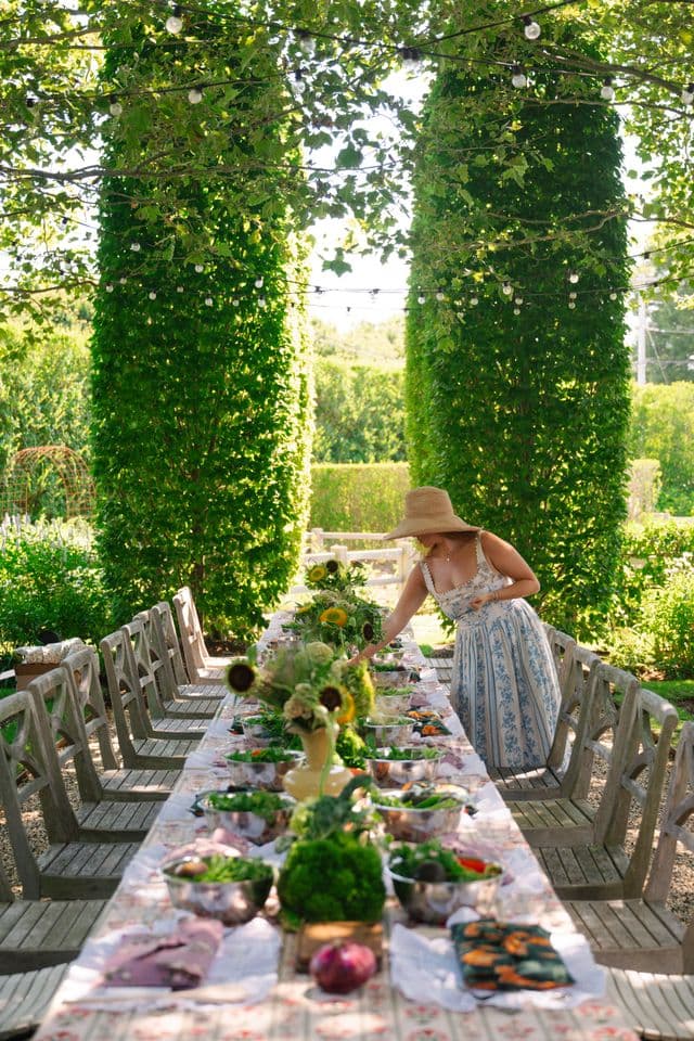 A planner finishing a long garden table set under string lights